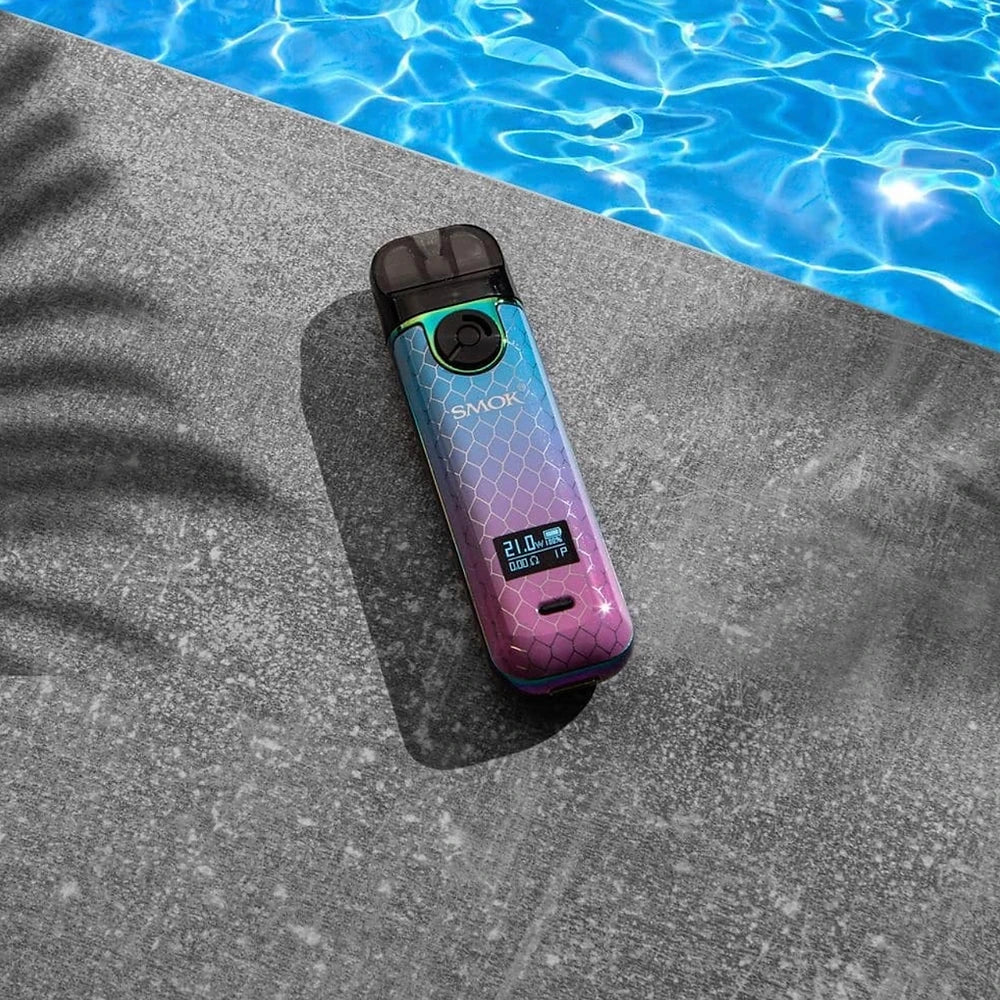 SMOK NOVO 4 Pod Kit - 25W in rainbow gradient design resting by a poolside, showcasing its portable and durable build for outdoor use.