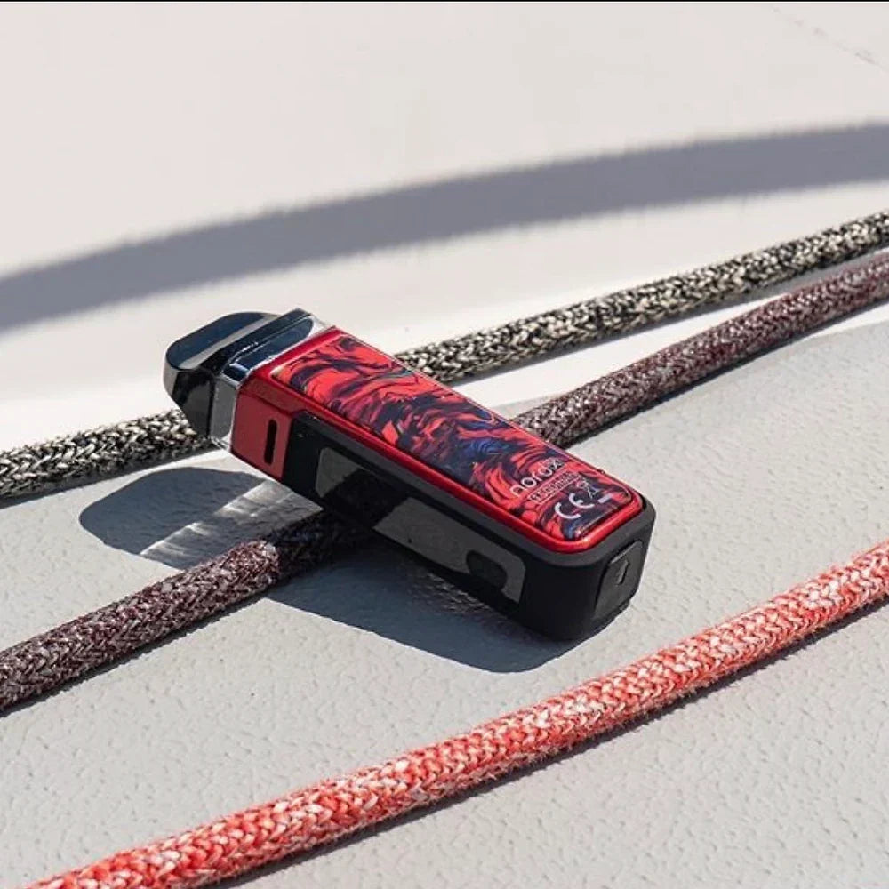 SMOK NORD X 60W Pod System in red-black design resting on boat deck, highlighting rugged IP67 water-resistant build.