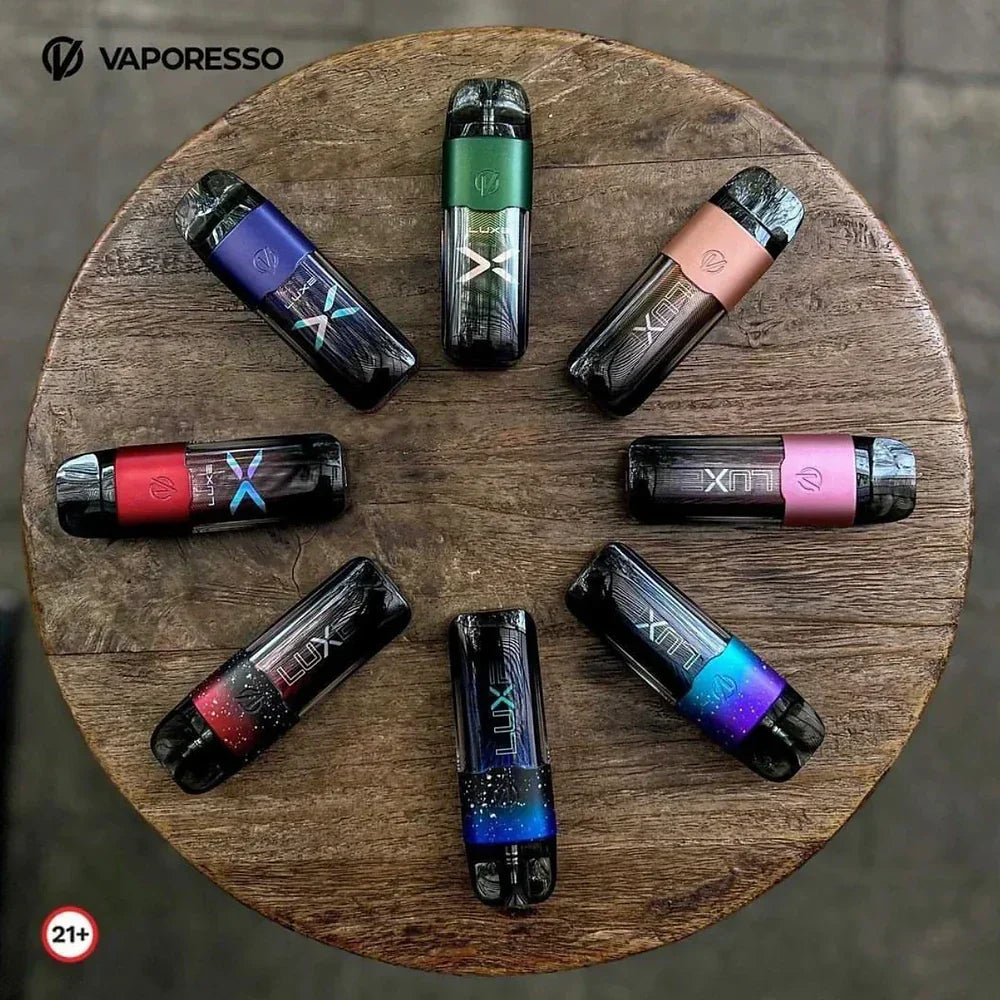 Collection of Vaporesso LUXE X 40W Pod Systems in various colors arranged in a circle on a wooden surface, showcasing design variety.