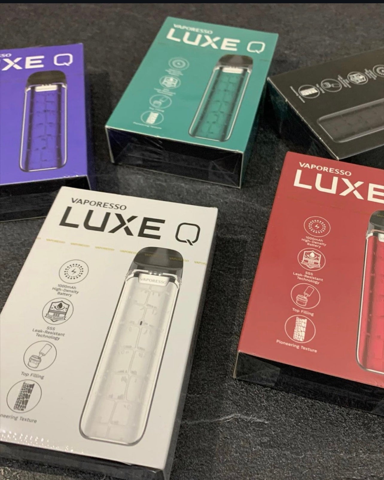 Assorted Vaporesso Luxe Q Pod System boxes in various colors including purple, green, white, and red, ideal for eJuice or nicotine salt.