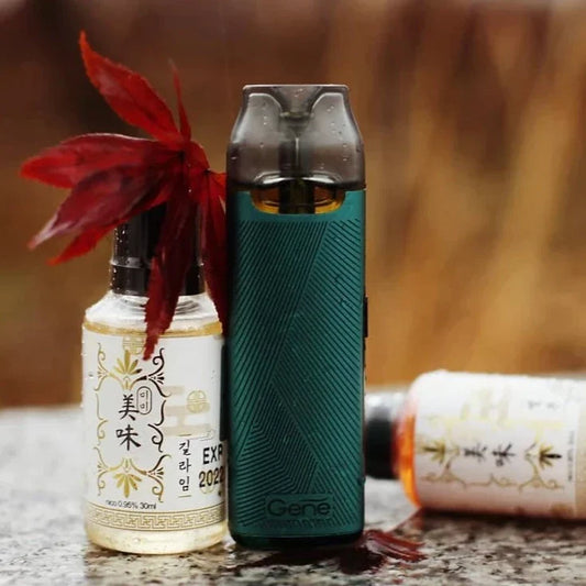 Green VOOPOO V Thru Pro Pod System 25W with 900mAh battery and 3mL pod capacity, displayed with e-liquid bottles on a stone surface.