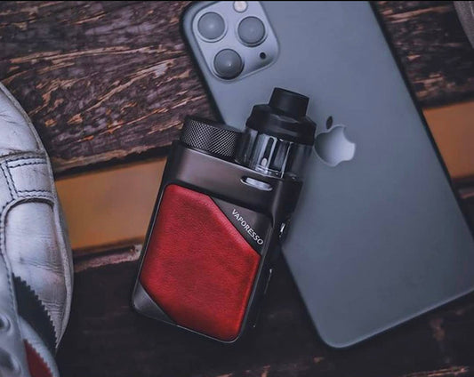 Vaporesso SWAG PX80 Pod Mod Kit - 80W, 4mL shown with red leather grip beside smartphone, highlighting compact power and stylish design.